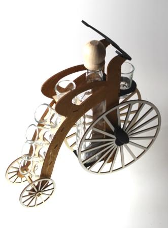 Štamperlíky a fľaša na drevenom stojane s motívom historického bicykla